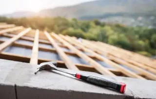 Roof Replacement or installation construction project that's half way done and hammer in the foreground